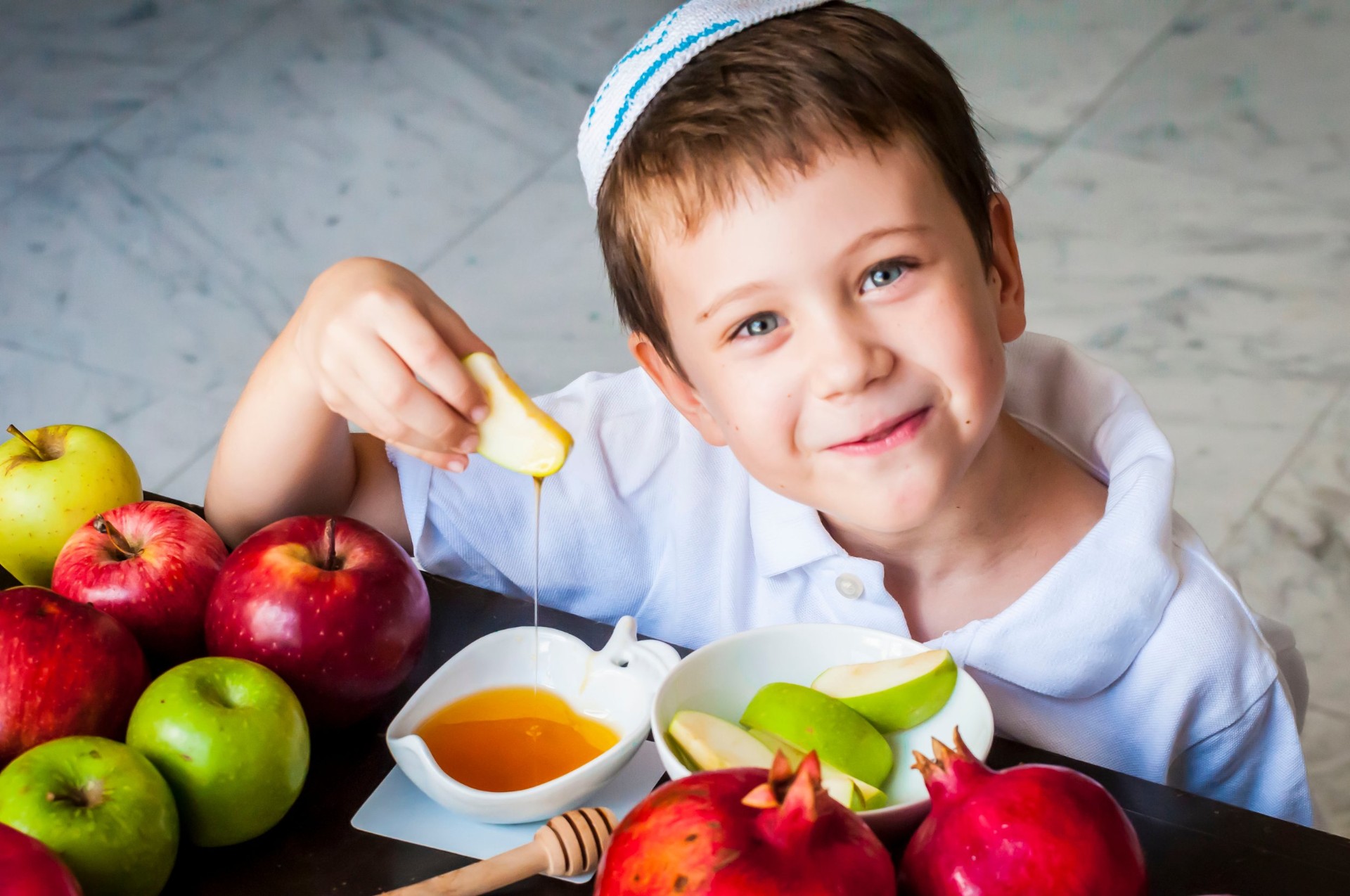 Child celebrating Jewish traditions with apples and honey